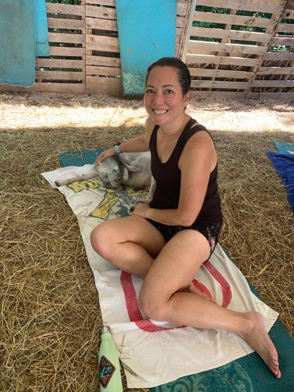 Petting a goat on my yoga mat during goat yoga.