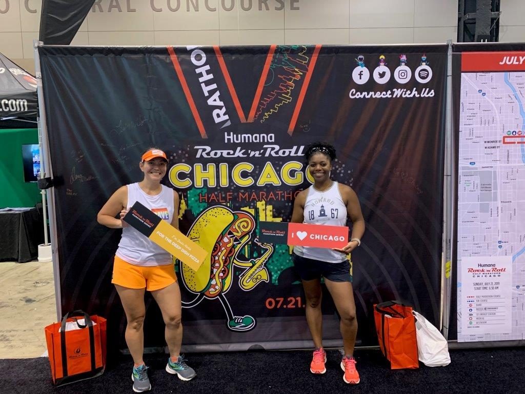 Standing in front of a Rock N Roll Chicago medal banner at the race expo.