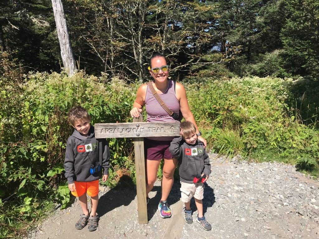 Standing in front of the Appalachian Trail sign by Clingmans Dome with my two boys.