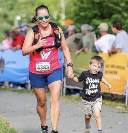 Running through the finish line with my youngest son who is wearing a Strong Like Mom shirt.