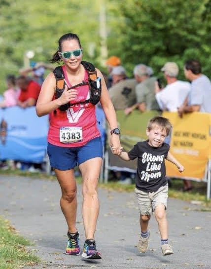 Running through the finish line with my youngest son who is wearing a Strong Like Mom shirt.