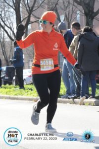Wearing my BibRave orange shirt and beanie as I cross the finish line at the Hot Chocolate 15k.