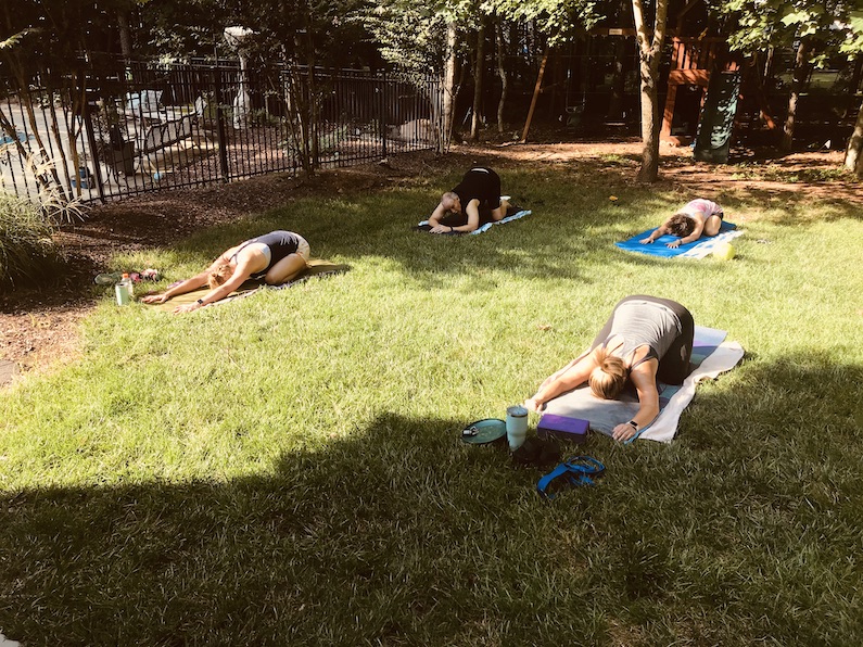 Students in child's pose outside in my backyard during one of my practice teaching classes.