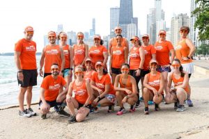 The BibRave Pro Summit team standing in front of the Chicago skyline at the lakefront.