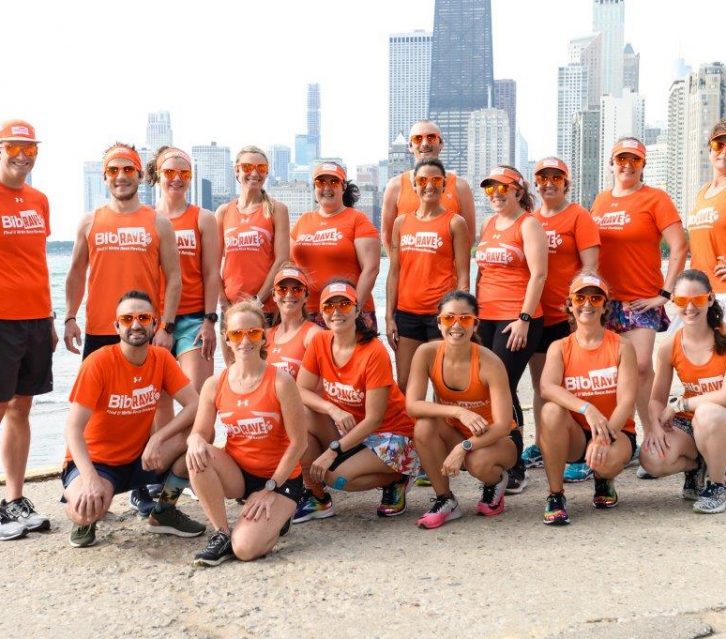 The BibRave Pro Summit team standing in front of the Chicago skyline at the lakefront.