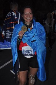 Wearing my blue NY marathon poncho and showing off my medal.